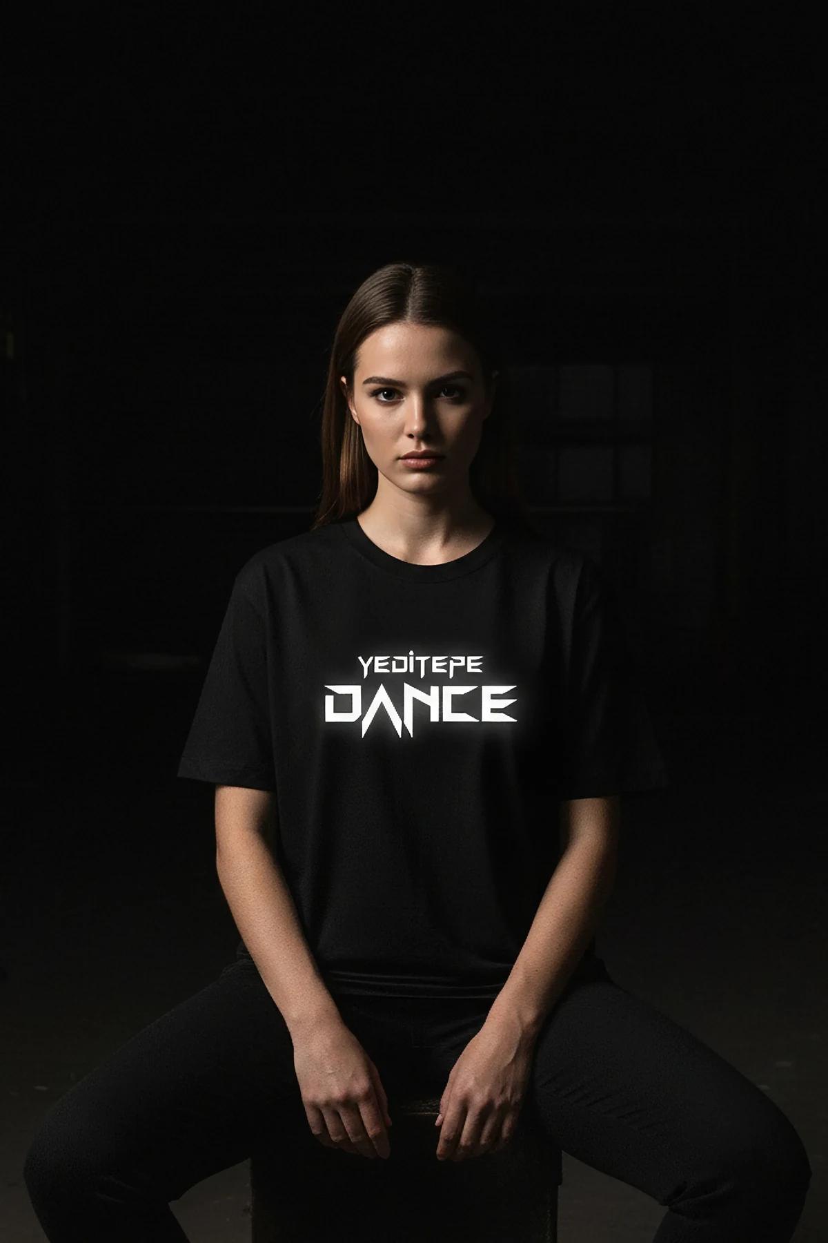 KÜLTÜR DANCE reflektörlü ön baskılı siyah oversize tişört, model üzerinde karanlık arka planda