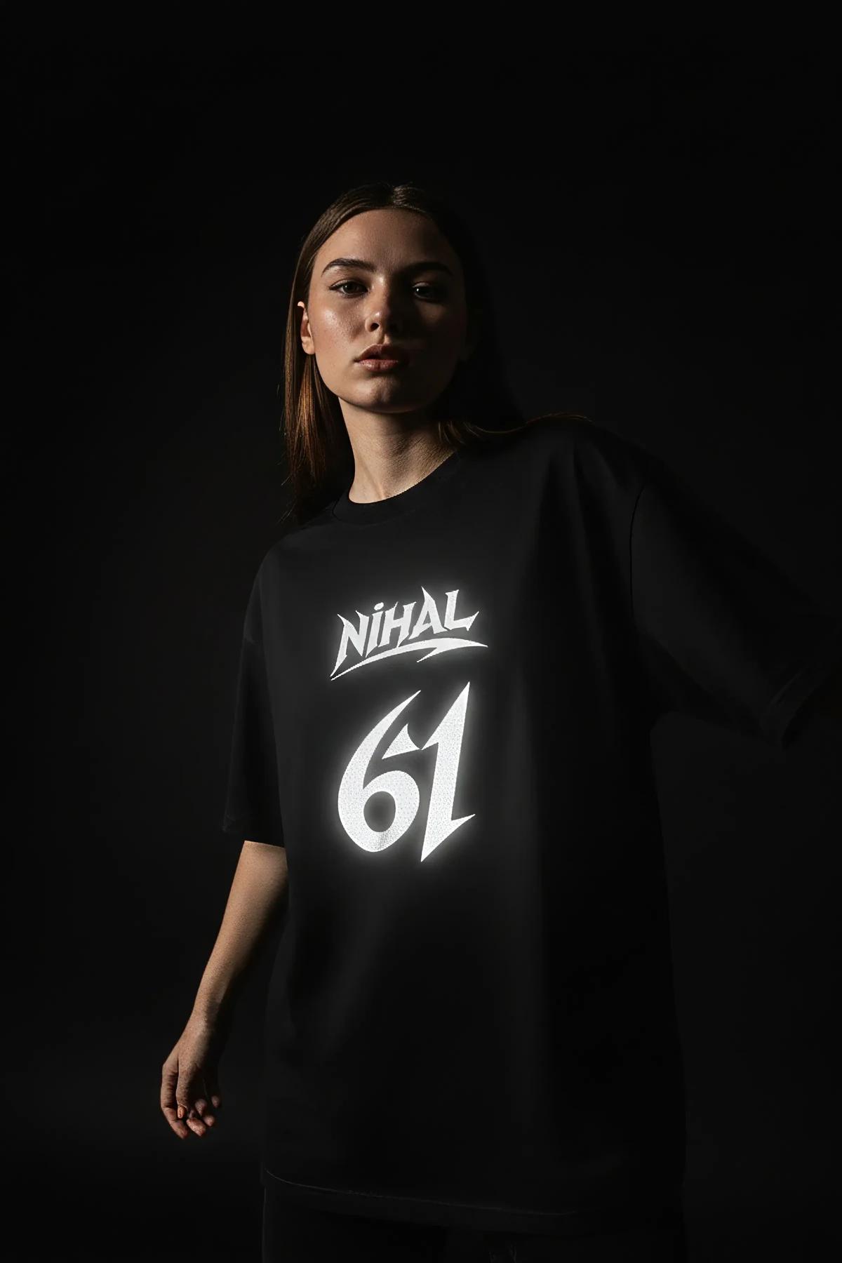 NİHAL 61 reflektörlü ön baskılı siyah oversize tişört, flaş ışığında parlayan yazı