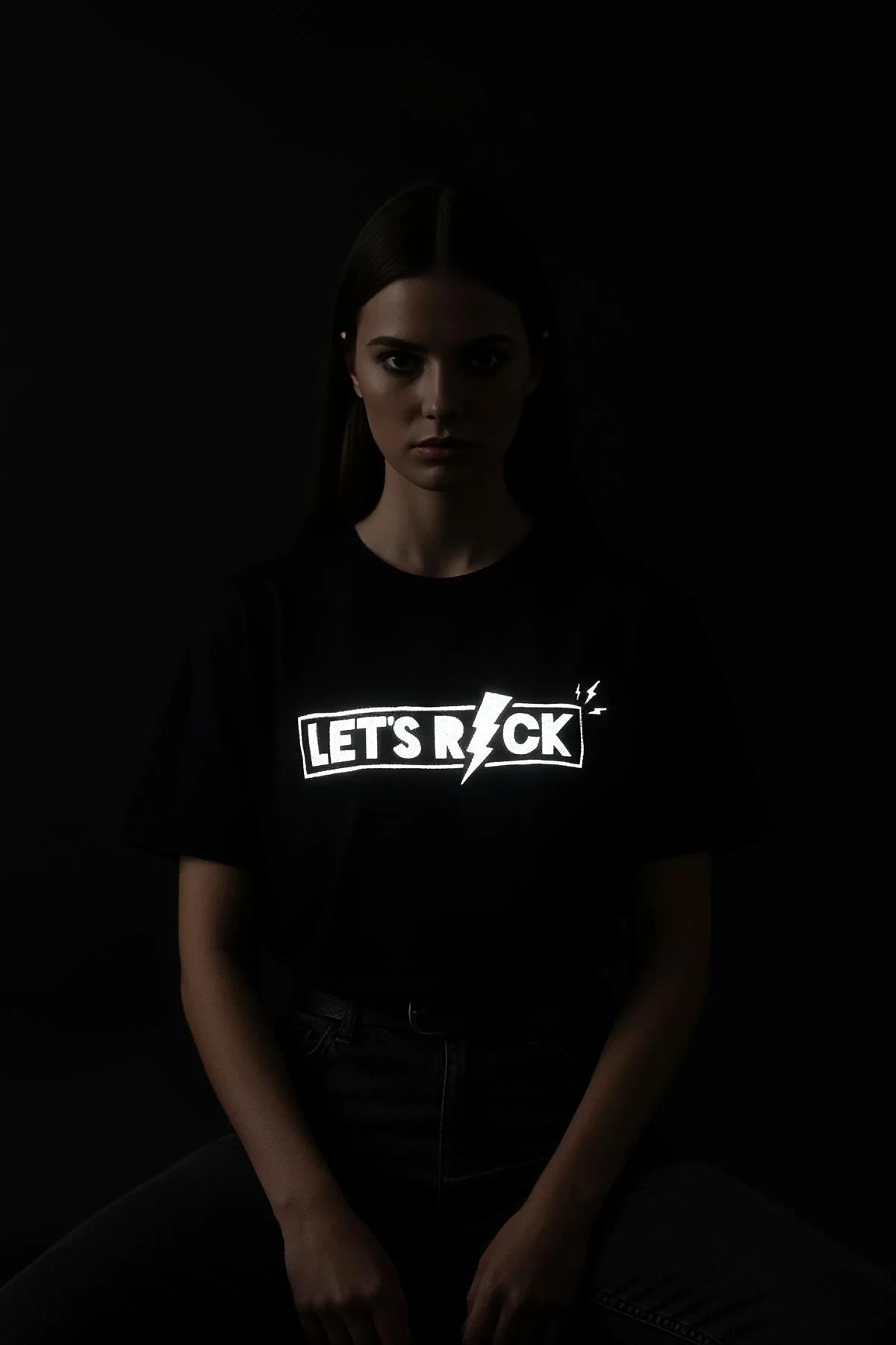 LET'S ROCK şimşek ikonlu reflektör baskılı siyah oversize tişört, ışık altında parlayan ön baskı, model üzerinde