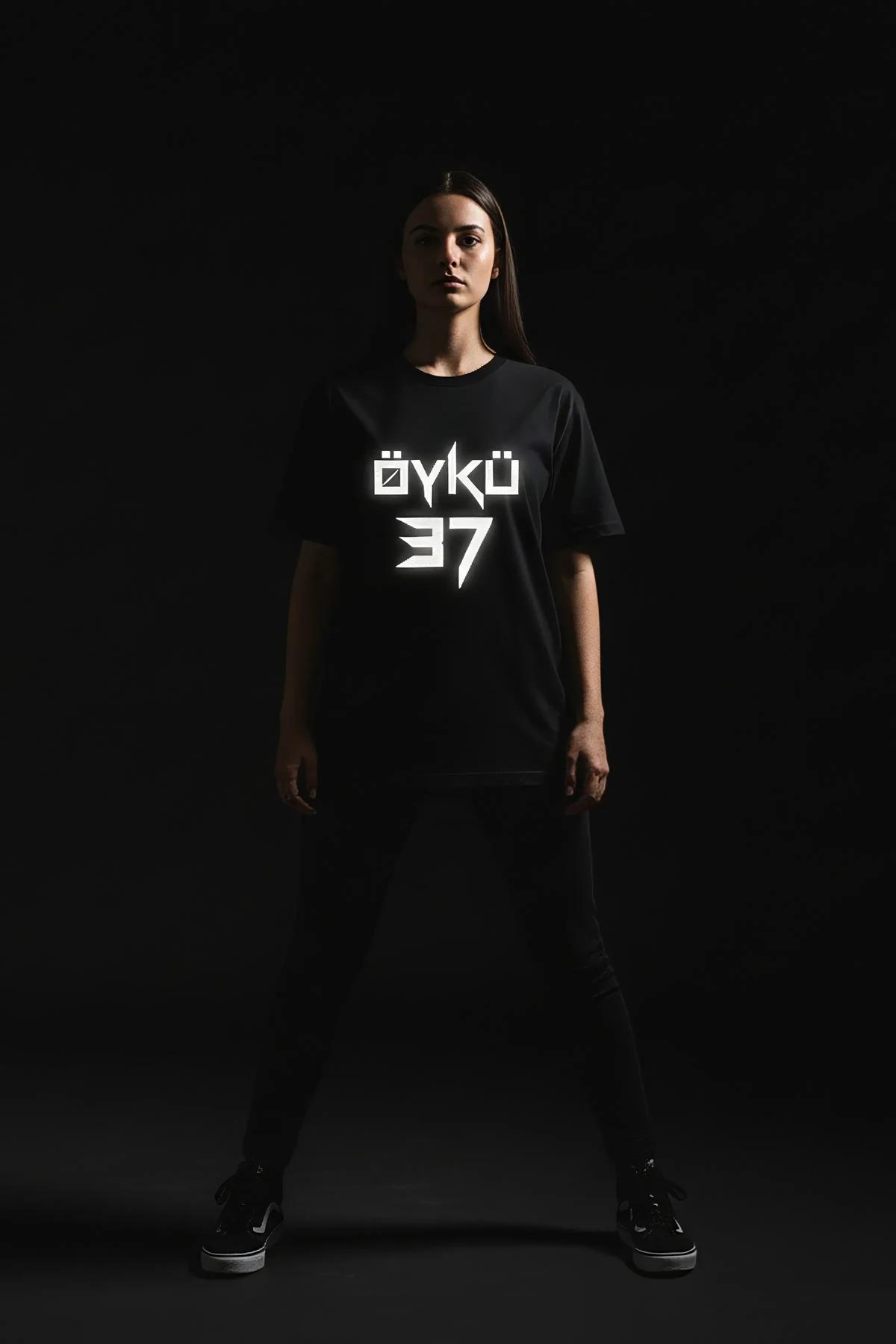 ÖYKÜ 37 reflektörlü ön baskılı siyah oversize tişört, yıldırım grafik detaylı, model üzerinde