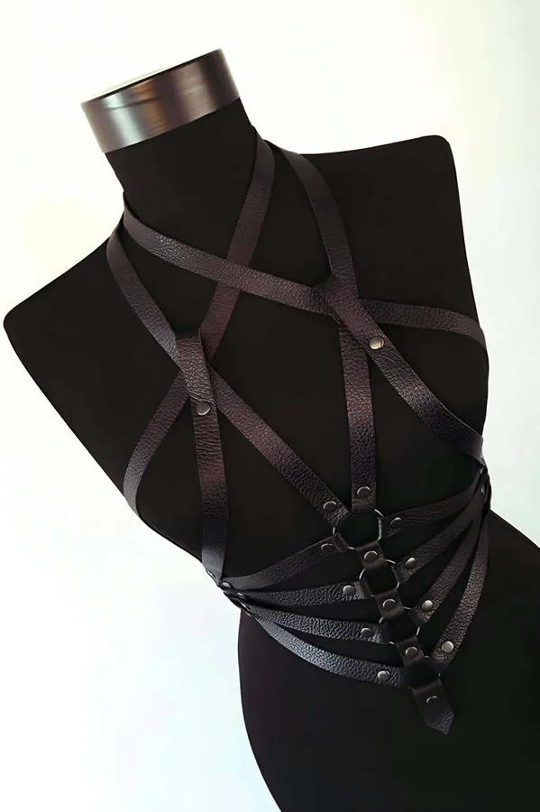 Black faux leather strappy chest harness with triple O-ring cluster and antique bronze studs on mannequin