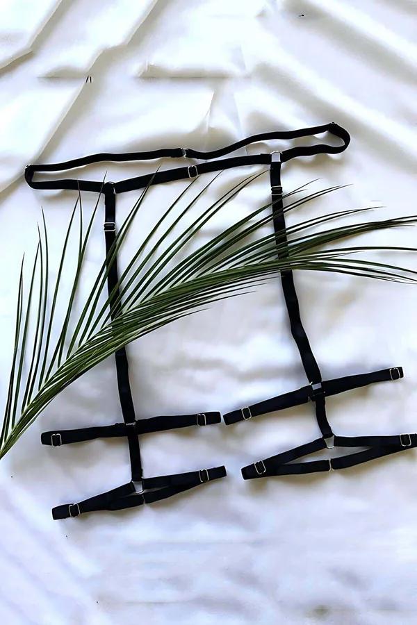 Black elastic strappy leg harness set with silver slider buckles and adjustable waistband laid flat