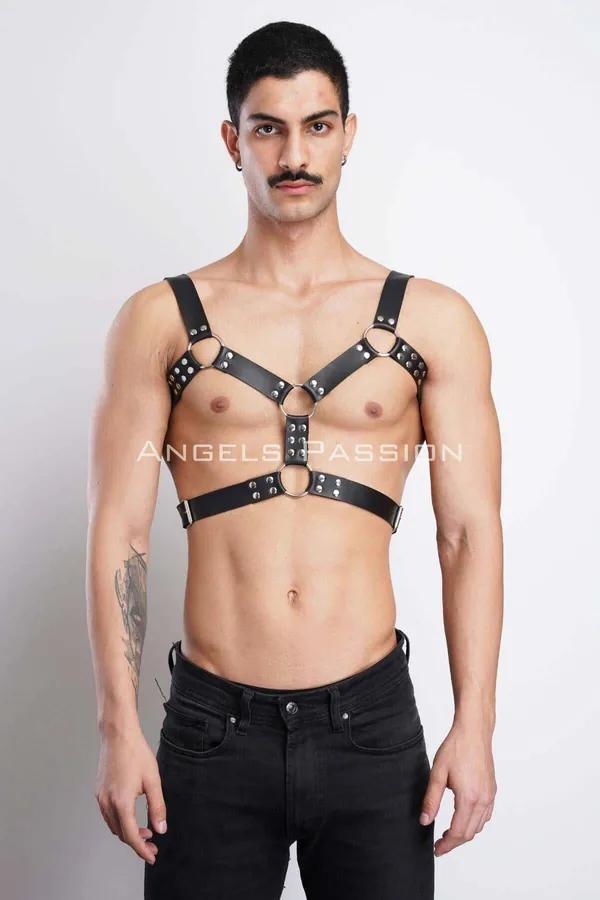 Black faux leather chest harness with silver dome studs and three O-rings worn by male model over bare torso
