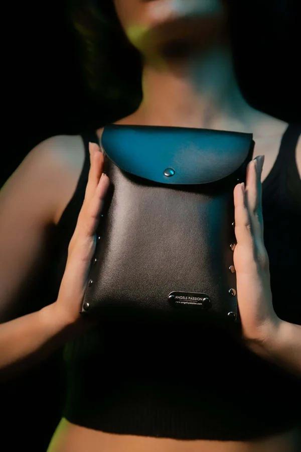 black faux leather structured pouch with silver dome studs on sides and snap closure envelope flap