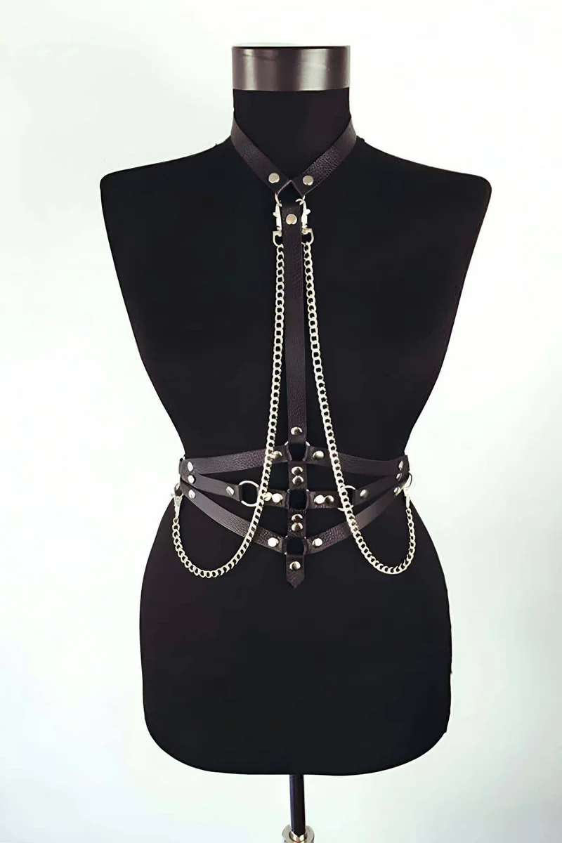 Close-up of silver chain detail on black faux leather body harness