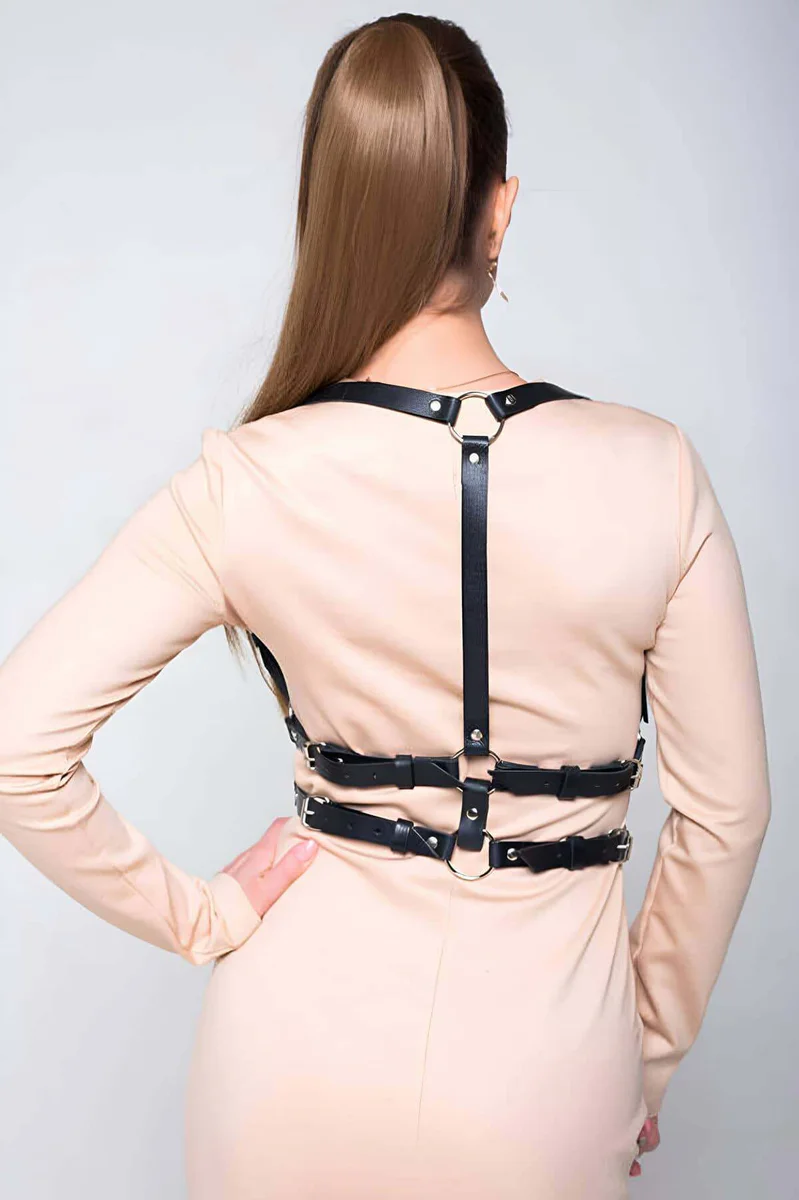 Close-up of black faux leather chest harness O-ring detail