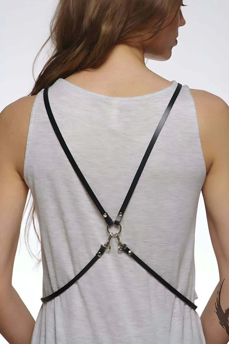 Black faux leather X-back body harness with O-ring detail worn over a white tank top