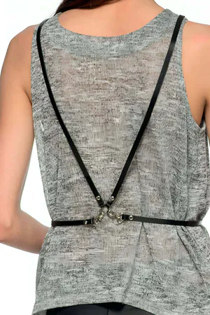 Black faux leather geometric body harness with O-ring accents on a woman