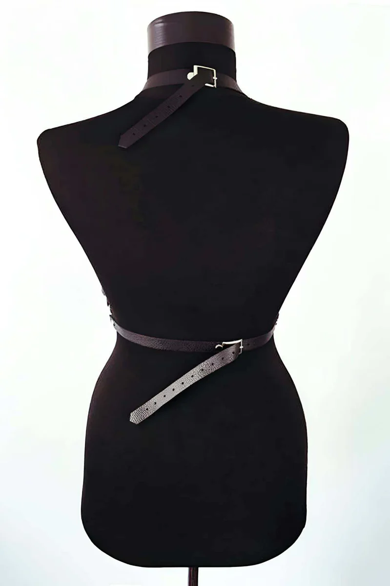 Close-up of O-ring hardware on black faux leather harness