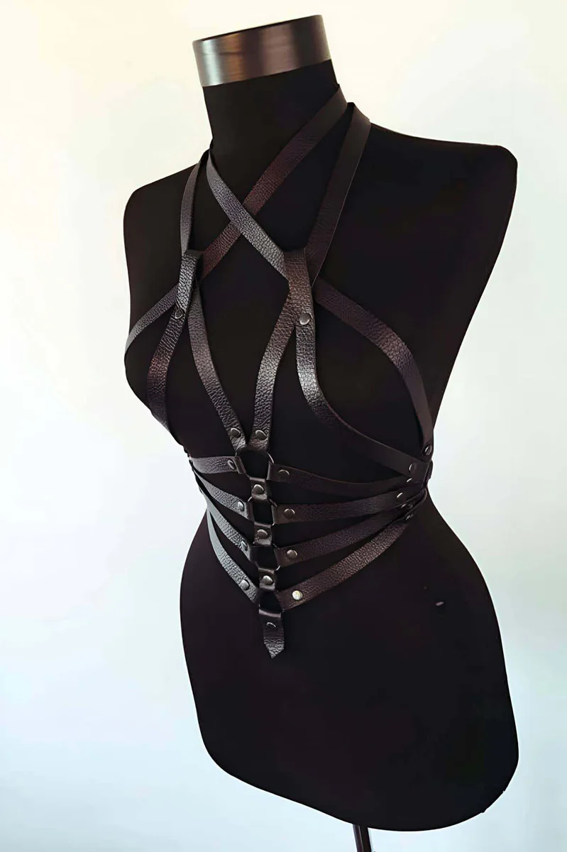 Black faux leather harness with crisscross straps and multiple O-ring details