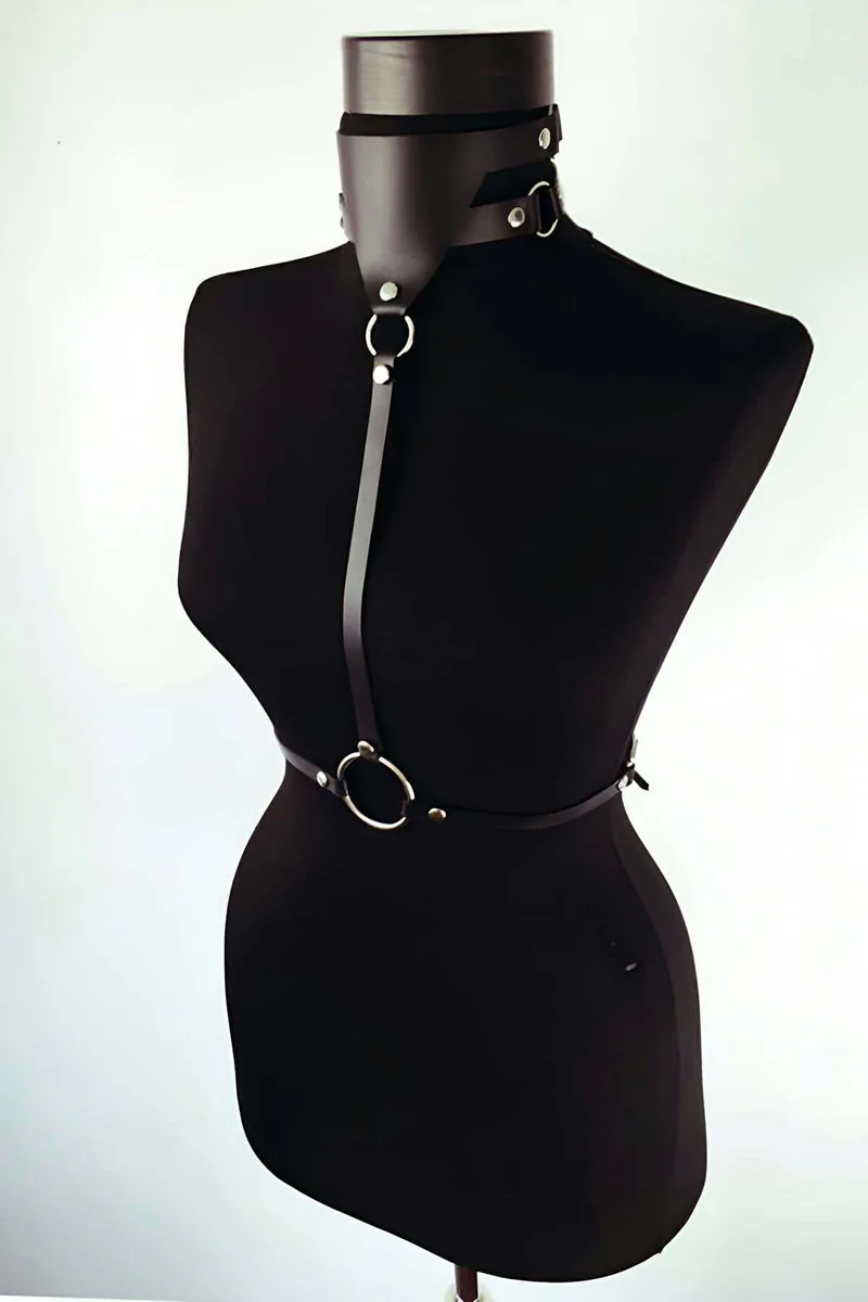 Black faux leather choker collar close-up with silver O-ring and harness detail
