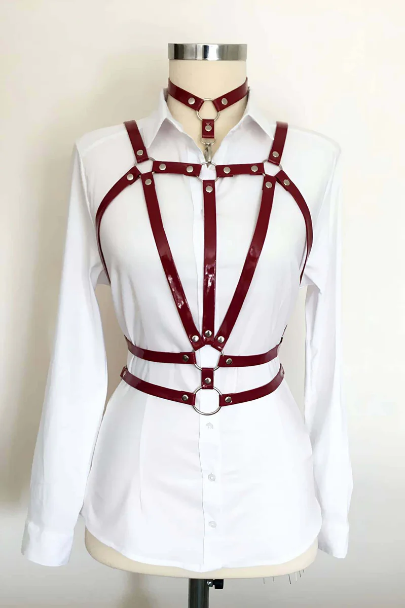 Crimson patent halterneck body harness with silver O-ring hardware on white shirt