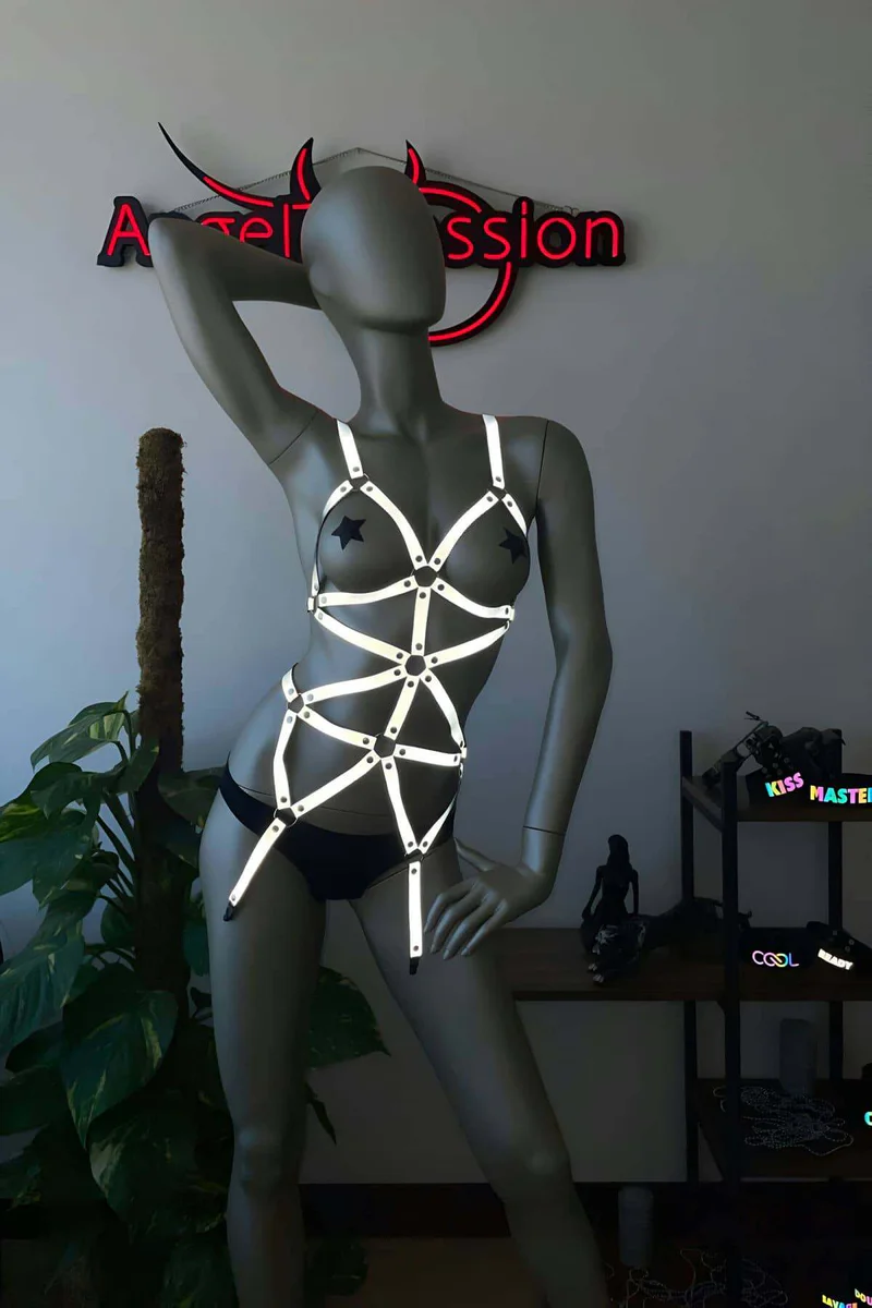 Festival outfit featuring a reflective body harness with star pasties and geometric straps