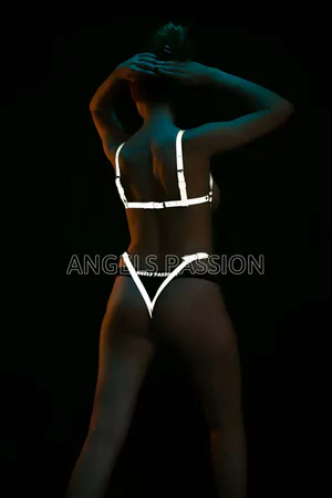 Reflective body harness with adjustable straps and O-ring detail worn by a model