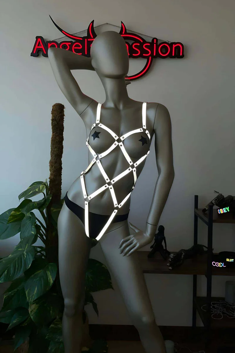 Model wearing reflective geometric harness with black bodysuit and star pasties