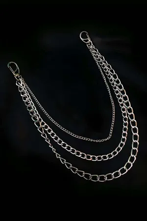 Silver multi-strand layered chain necklace with mixed links worn over black t-shirt