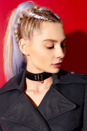 Black faux leather choker collar with D-ring detail on a person wearing a black coat