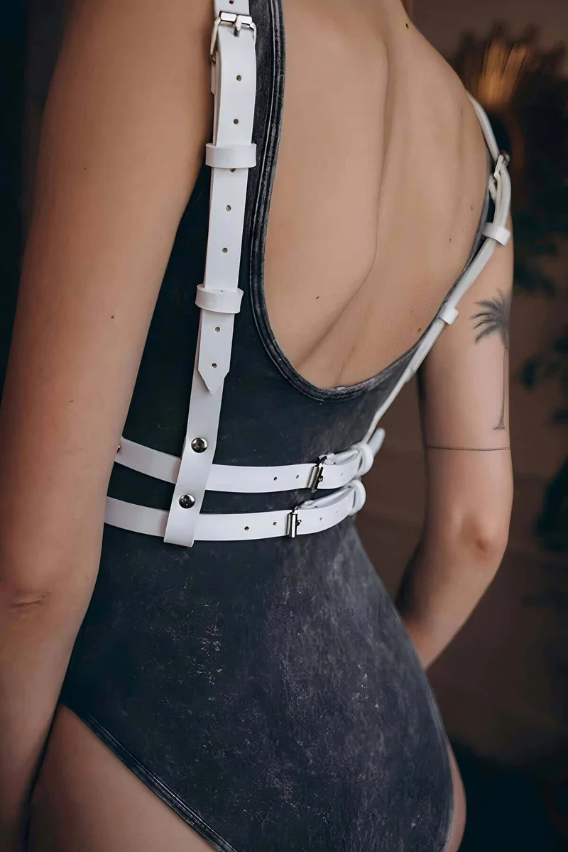 Adjustable straps on white faux leather chest harness, side view