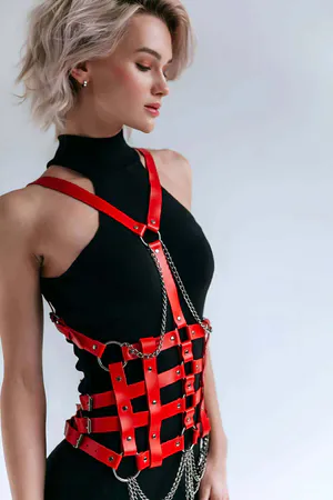 Red faux leather body harness with silver chain detail and adjustable straps