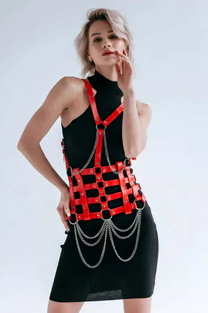 Red faux leather body harness with silver chain detail and adjustable straps
