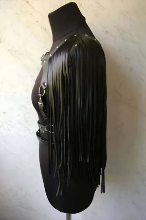 Black faux leather body harness with cascading fringe and studded belt.