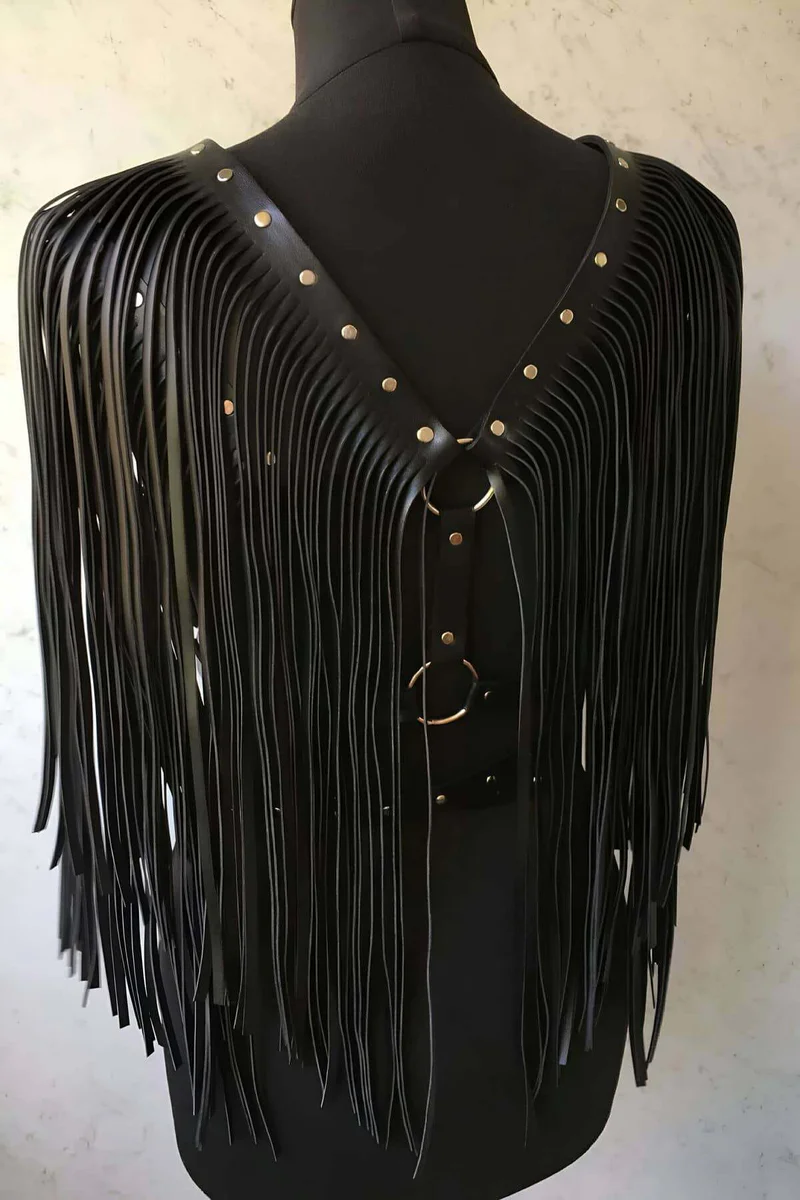 Black studded accent belt of the body harness showing metal studs and fringe detail