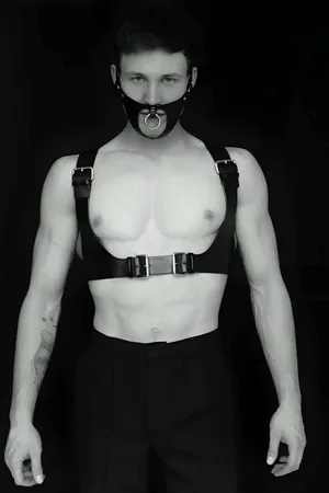 Black faux leather full body harness with detachable O-ring gag mask, silver buckle details.