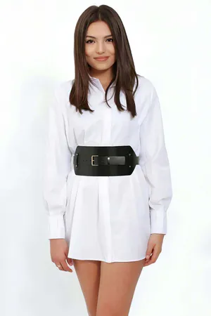 Black wide faux leather waist belt with silver buckle worn over a white shirt dress