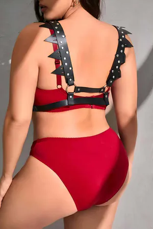 Black faux leather spiked chest harness with silver hardware on a model