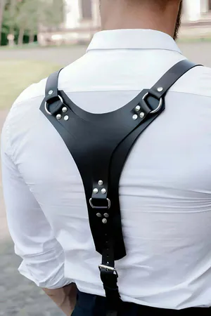 Black faux leather Y-back body harness with O-ring, worn over a white shirt