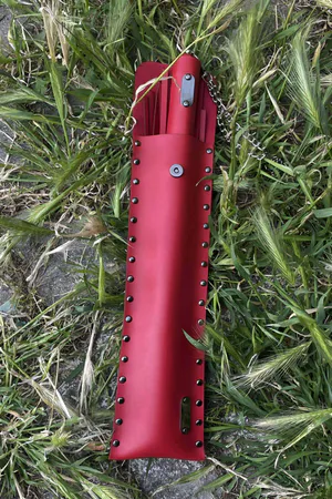 Red Faux Leather Flogger with Riveted Storage Pouch on grass