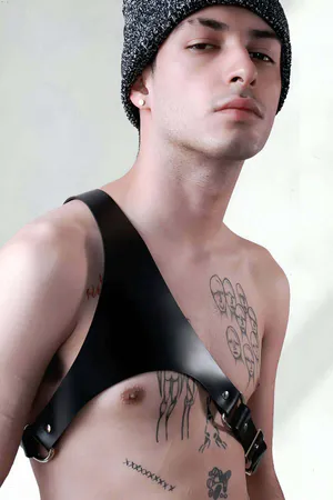 Black faux leather single shoulder harness with silver buckle on chest
