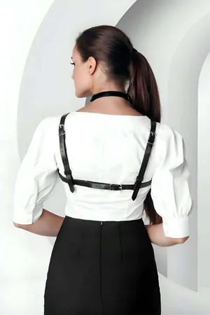 Black faux leather strappy O-ring chest harness on a model