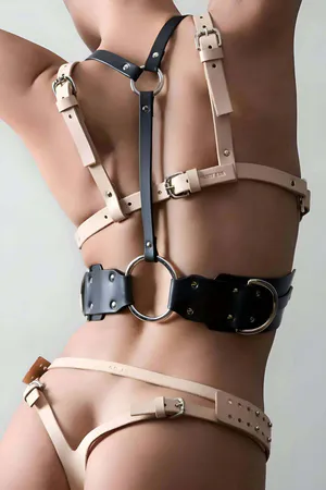 Black and natural tan faux leather body harness with O-ring, adjustable straps, and studded waist belt