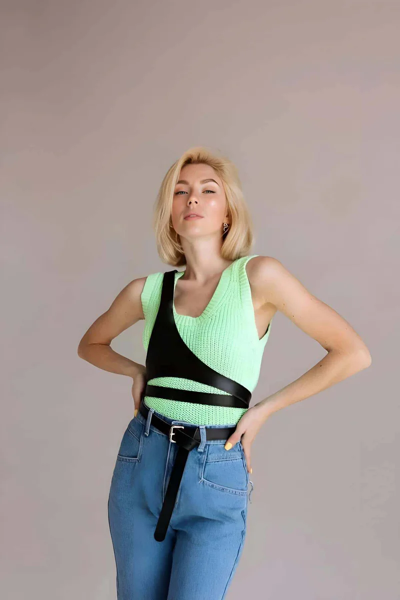 Black faux leather strappy chest harness worn by a model
