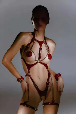 Red faux leather full body harness with gold chains and matching cuffs