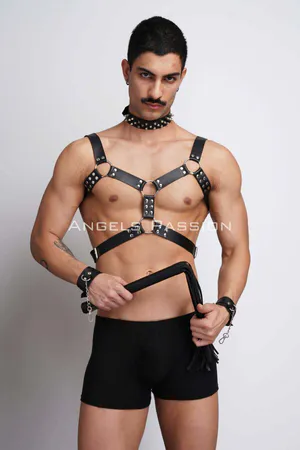 Black faux leather chest harness with studded details, spiked choker, and cuffs, worn by a male model.