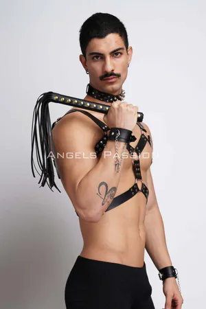Black faux leather chest harness with studded details, spiked choker, and cuffs, worn by a male model.
