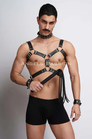 Black faux leather chest harness with studded details, spiked choker, and cuffs, worn by a male model.