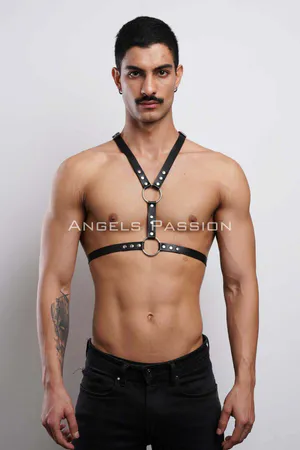 Black faux leather adjustable body harness with O-ring and rivets, worn by a male model.