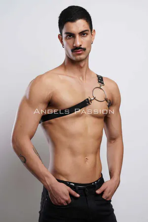 Black faux leather chest harness with silver O-ring and adjustable strap on a man