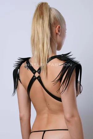 Black faux leather shoulder harness with cascading fringe detail on model's back