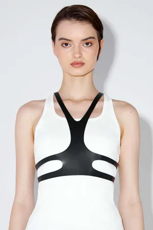 Black faux leather minimalist chest harness worn over white tank top