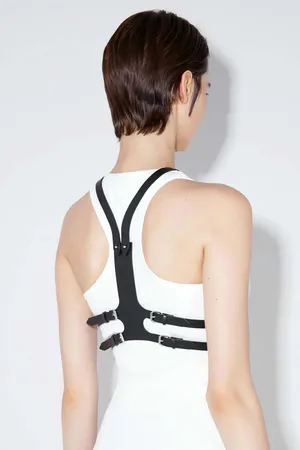 Black faux leather minimalist chest harness worn over white tank top
