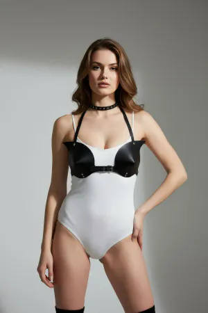 Siyah suni deri korse detaylı vücut aksesuarı, beyaz bodysuit ve siyah topuklu ayakkabılarla birlikte model üzerinde