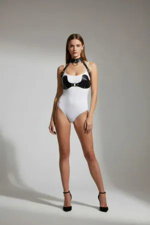 Black faux leather chest harness with central O-ring detail, worn by a model