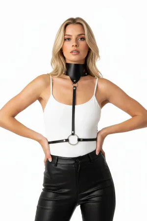 Black faux leather high collar body harness with central O-ring and adjustable straps on a woman