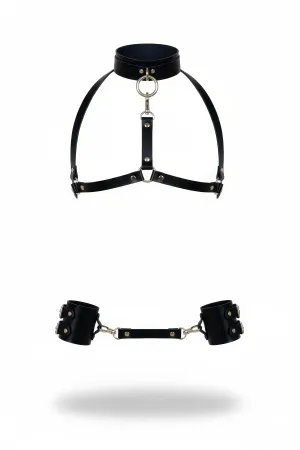 Black vegan leather body harness with adjustable straps and central O-ring, paired with detachable wrist cuffs.