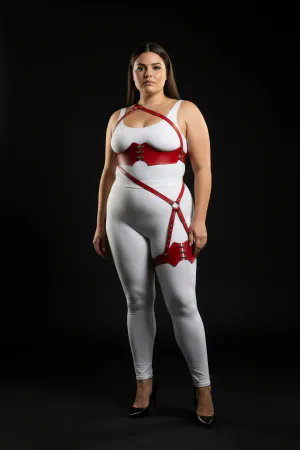 Red vegan leather strappy body harness with O-ring leg detail worn by a model