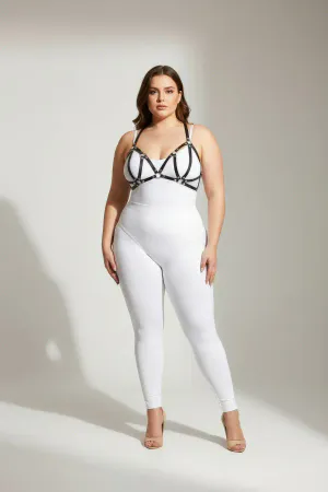 Black faux leather strappy chest harness with silver O-ring hardware, worn by a plus-size model.